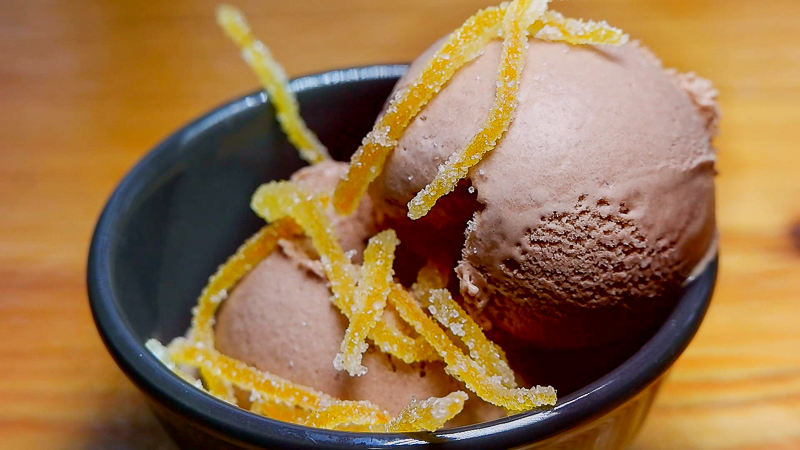 dos bolas de helado de chocolate a la naranja decorado con tiras de naranja confitada